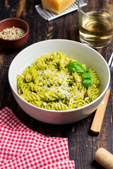 Fusilli pasta with pesto sauce, cheese and nuts. Healthy eating. Vegetarian food. Italian cuisine.