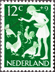 Netherlands - circa 1962: a postage stamp from the Netherlands, showing a girl feeding the chickens