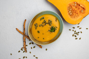 pumpkin soup garnished with pumpkin seeds on a white background