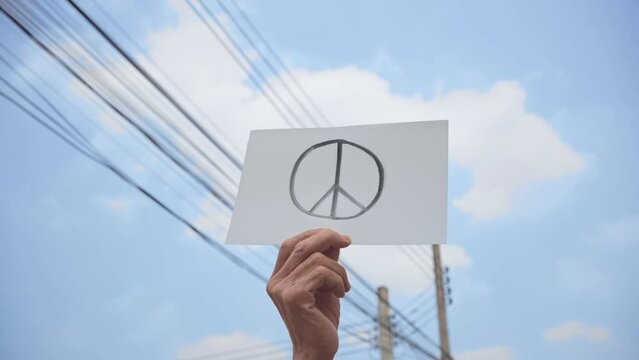 Demonstrator holding paper with peace symbol