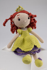 Knitted baby doll over gray background  