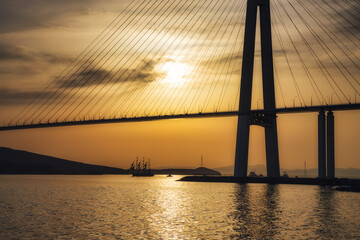 Silhouette of a sailboat under the cable-stayed bridge in Vladivostok, Russia