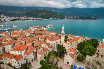 Naklejka na ściany i meble Aerial view of Budva old town with mighty sea waves, famous touristic place in Montenegro