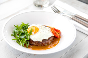breakfast fried eggs with beefsteak, arugula and sun-dried tomato