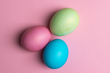Fototapeta na wymiar three painted eggs lie on a pink background