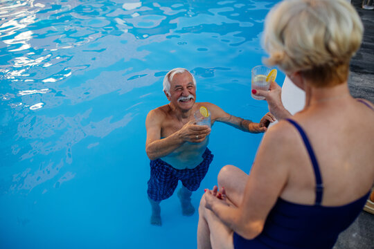 Senior Couple Cheering With Lemonade At The Pool