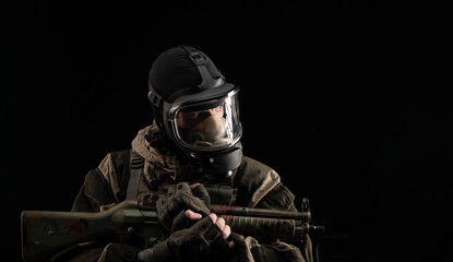 Fototapeta na wymiar a man in a military uniform and a gas mask holds a weapon with an angry expression of emotion