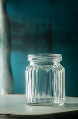 empty glass jar or shot drink jar over rustic wooden background, transparent glass