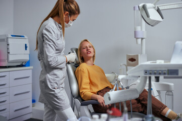 Fototapeta premium Female dentist and a patient in the dental office