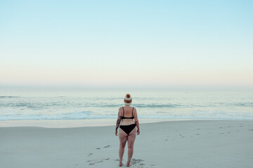Rearview of a winter bather standing at the beach in swimwear