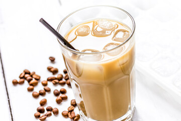 cold coffee glass with ice cubes on white table background