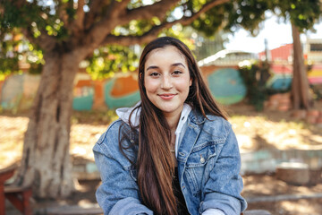 Happy teenage girl looking at the camera cheerfully