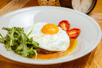 breakfast fried eggs with beefsteak, arugula and sun-dried tomato
