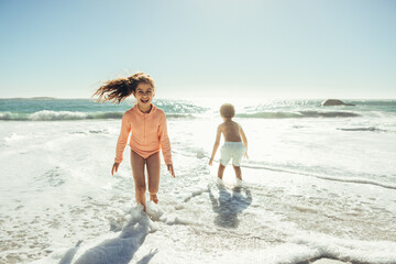 Fototapeta premium Active little girl playing in sea water at the beach