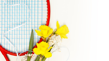 Tennis. Holiday sport composition with tennis racket with bouquet of daffodils on a white...