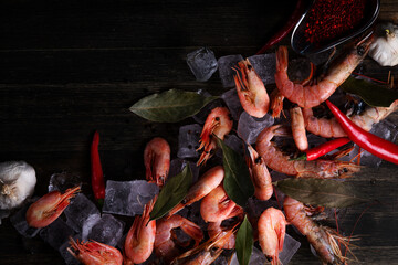 shrimps in ice with pepper and bay leaf on a wooden background