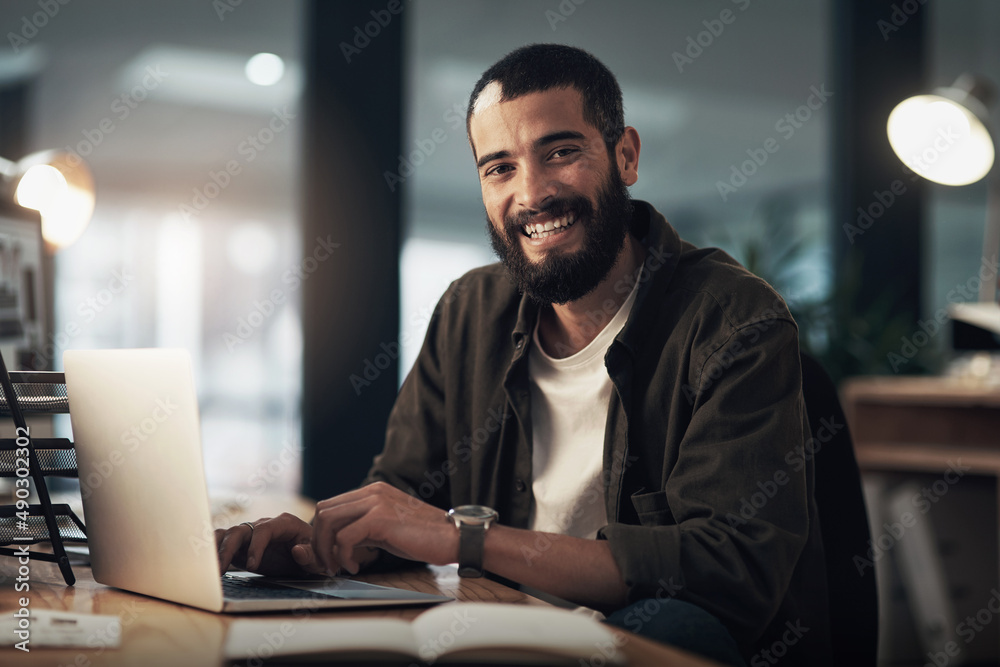 Poster the tech that gets my designs done on time. shot of a young businessman using a laptop during a late