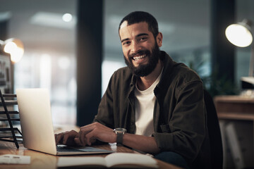 The tech that gets my designs done on time. Shot of a young businessman using a laptop during a late night at work.