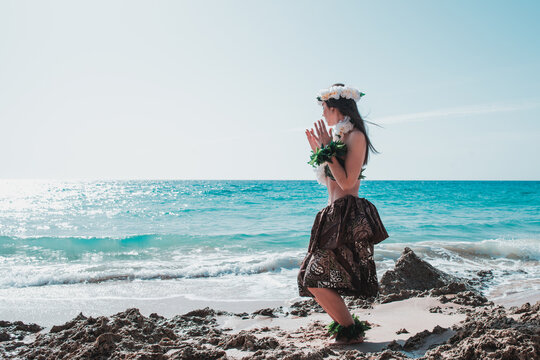 Fototapeta Hawaiian woman enjoys hula dancing on the beach barefoot wearing traditional costume. Unrecognizable hawaiian hula dance dancing attire hawai.