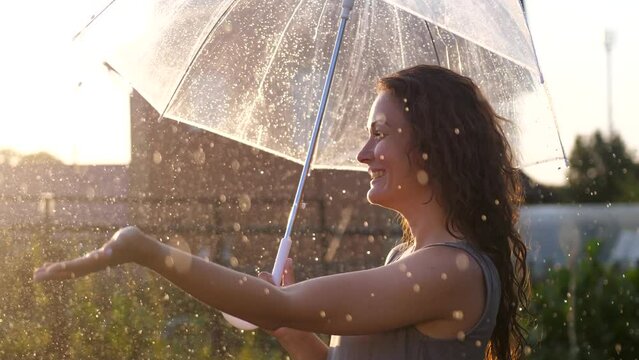 Happy young woman enjoying and having fun with umbrella outdoor at sunny weather. slow motion