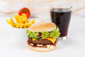 Hamburger Cheeseburger meal fastfood fast food with cola drink and French Fries on a wooden board