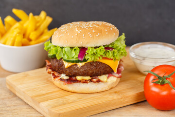Hamburger Cheeseburger fastfood fast food with French Fries on a wooden board