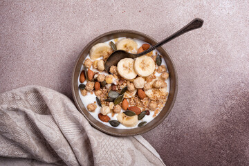 Healthy breakfast of granola with nuts, banana and yogurt