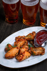 fried chicken wings served with beer on a dark background