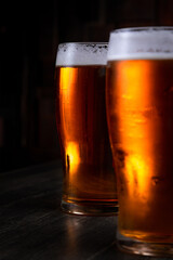 a glass of foamy beer on a dark background