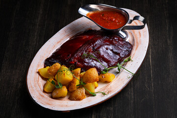 barbecued ribs with grilled potatoes and red sauce