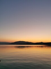 yellow, red sunset, lake, blue water, mountains