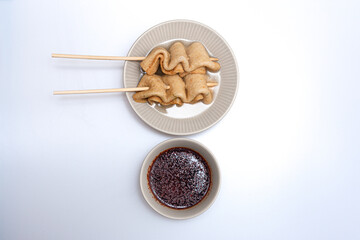 Fish cake skewers in a bowl on a white background
