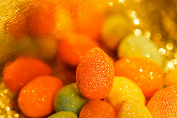 Blurred background with Easter colorful eggs and bokeh on a shiny yellow surface.The artistic intend and the filters.
