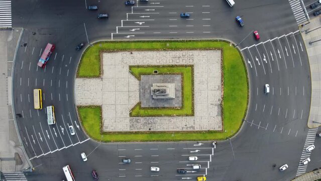 A roundabout in Lima, Peru. Drone 4k footage, slowly descending altitude. Cars and buses going around a monument in the middle of the round about.