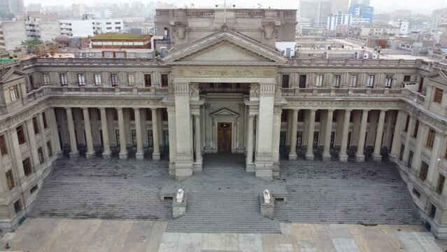 Peru's palace of justice, palacio de justicia. Drone 4k footage. Quickly flying backwards while ascending altitude. Ending with the view of peruvian flag in the distance.