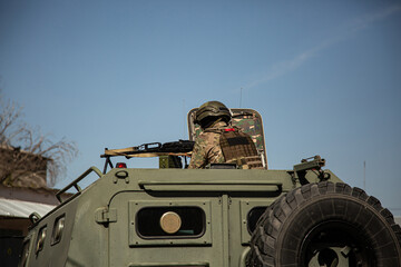 Military operations in Ukraine. A soldier with a machine gun on the roof of an armored personnel...