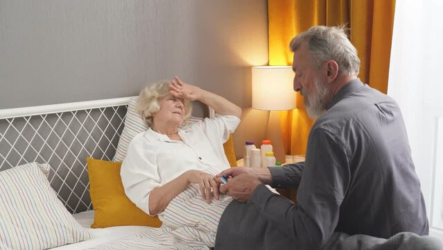 An elderly couple is experiencing a serious illness. Senior man check the pulse width Pulse Oximeter