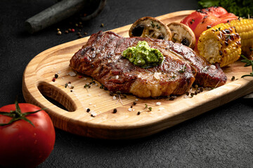 steak served on a wooden tray with grilled vegetables