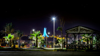The Maqam Echahid, Martyrs' Memorial , low angle view from sablettes promenade park by night. Palm...