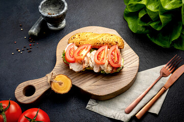 sandwich with minced meat, with herbs and tomatoes. on a dark background