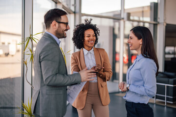 Smiling diverse colleagues, discussing their company protocols.