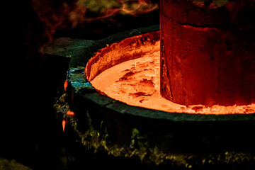 Foundry production. Molds filled with molten metal. Close-up. Soft focus