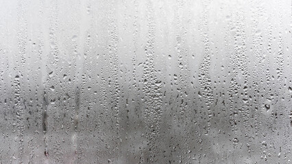 Fototapeta premium Texture of the rain on the glass, steamy window with water drops made in dull day