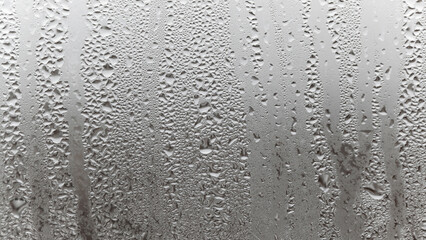 Texture of the rain on the glass, steamy window with water drops made in dull day