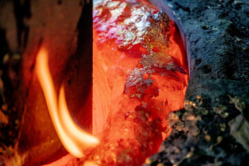 Foundry production. Molds filled with molten metal. Close-up. Soft focus