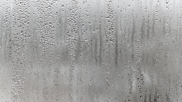 Texture of the rain on the glass, steamy window with water drops made in dull day