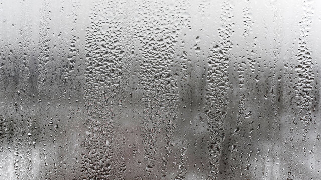 Texture of a drop of rain on a glass wet transparent background, humidity and foggy blank