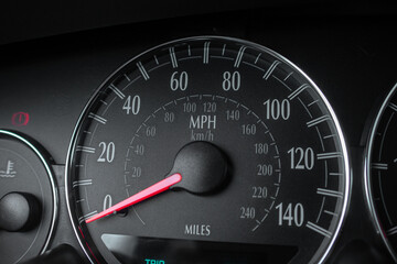 car speedometer with red arrow , in miles