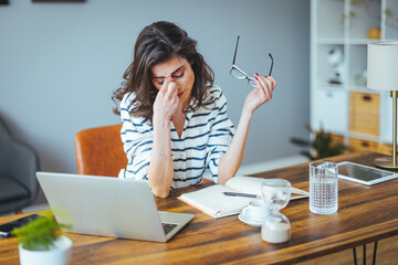 Shot of a young businesswoman looking stressed out while working in an office. Confused...