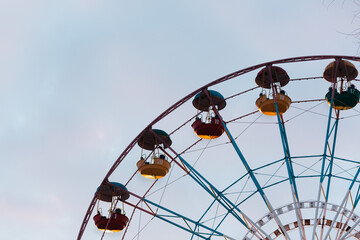 Ferris wheel with multicolored bottom highlighted cubs against cloudy blue sky